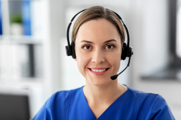 medicine, technology and healthcare concept - happy smiling female doctor or nurse with headset and...