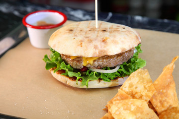 Burger with meat and vegetables. Double cheese burger. Hot burger in a burning sauce. 