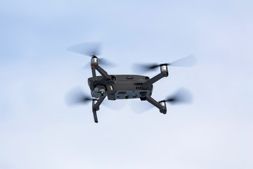 Drone with a camcorder against a clear sky