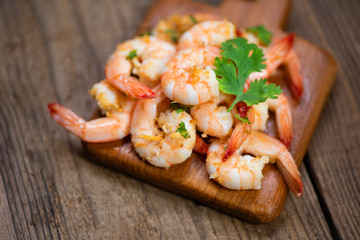 Shrimp delicious seasoning spices on wooden cutting board background /  cooked shrimps or prawns Seafood shelfish