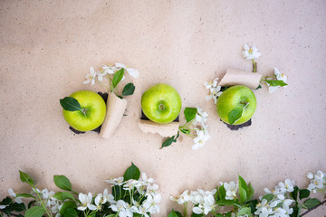 Three fresh juicy green granny smith apples on craft paper surface. View from above, flat lay, copy space. Healthy vitamin food or vegetarian concept
