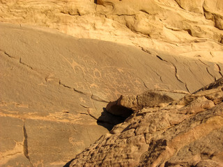 Ancient rock paintings on the orange rocks of Wadi rum in the Jordanian part of the Arabian desert .