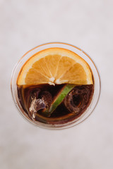 Non-alcoholic cocktail with orange and ice in a glass glass, refreshing summer drink, top view