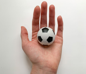 Fototapeta premium A small soccer ball in the hand of a girl on a white background.