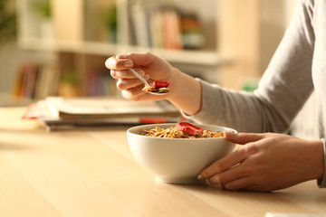 Woman hands eating breakfast cereal bowl at home