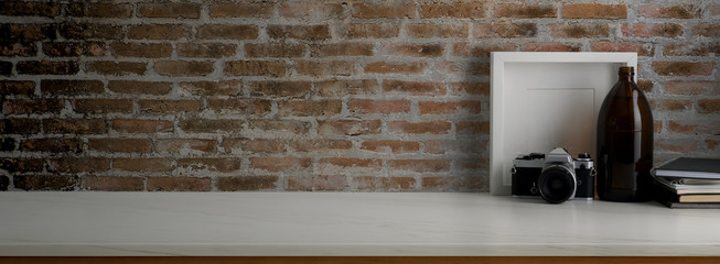 Close up view of contemporary worktable with decorations on marble desk with brick wall