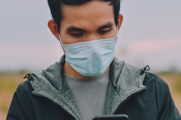 Man use medical face mask and play on mobile smart phone,People life in new normal