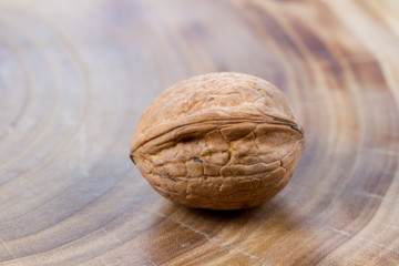 Walnuts close-up on a table from a cut of a poplar trunk, growth rings. Burnt wood texture.