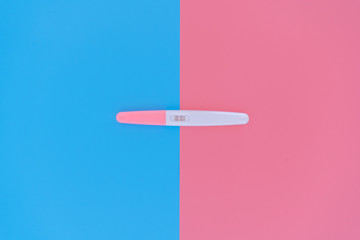 pregnancy test on pink and blue background