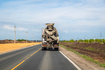Concrete mixer rides on the road, carrying concrete to the construction site.