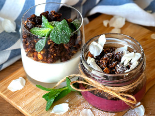 two desserts in a glass. Berry-curd dessert with granola. On a wooden board. 