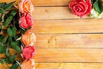 Handmade roses lie on a wooden background. Background layout with free text space.