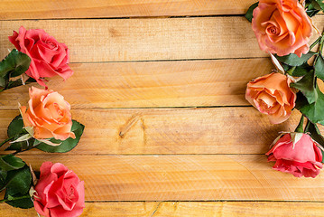 Handmade roses lie on a wooden background. Background layout with free text space.