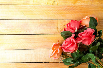 Handmade roses lie on a wooden background. Background layout with free text space.