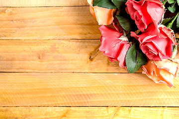 Handmade roses lie on a wooden background. Background layout with free text space.