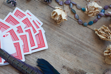 fortune-telling with cards, magic owl, dried roses, nut, birds' feather on wooden background