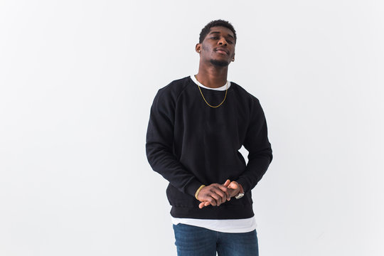 Portrait handsome young black man dressed in jeans and sweatshirt on white background with copyspace. Street fashion and modern youth culture.