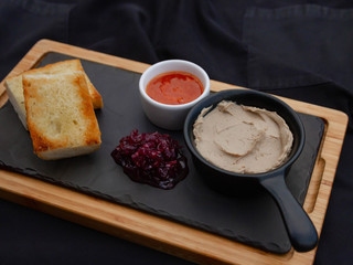Pate on a serving board with sauce, beetroot garnish and toasted bread