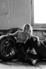 Fototapeta na wymiar a girl in a car service works with tires