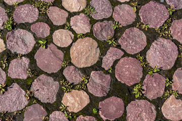 Sidewalk from stones of natural red granite, background and texture