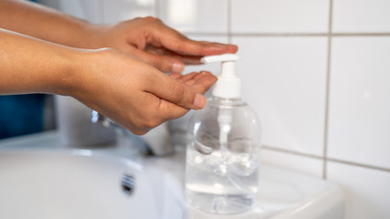 woman hands using wash hand sanitizer gel dispenser, against Novel coronavirus or Corona Virus Disease (Covid-19) at public