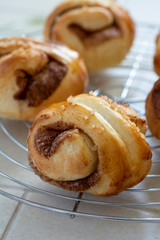 自宅でパン作り　シナモンロール　焼きたてのシナモンロールをケーキクーラーの上に並べる