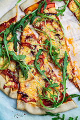 Obraz na płótnie Canvas Vegan homemade pizza with tomato sauce, pepper, vegan cheese and arugula, top view. Healthy vegan food concept.