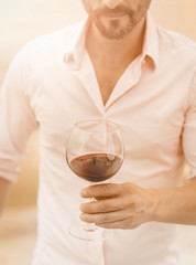 Bearded man holds a glass of red wine