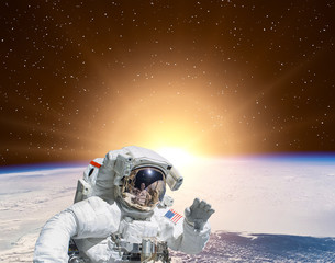 Planet earth and fascinating sunrise. Astronaut on backdrop. The elements of this image furnished by NASA.