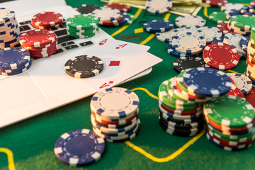 Chips, cards money and laptop for poker online or casino gambling. Risk for win money.
