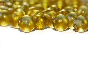 Yellow fish oil in capsules on a white background. Omega3 vitamins close-up. Capsules fish oil macro. Vitamins for health.
