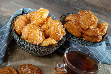 Chouquette, french choux pastry and tea on the wooden table
