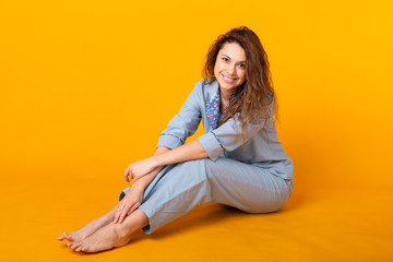 Close up young woman in blue home wear. Isolated on yellow background. Pajama concept.