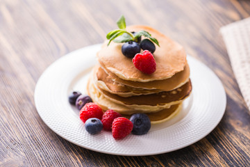 Close-up delicious pancakes with fresh blueberries and raspberries.