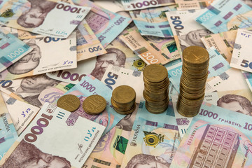 Close up coin stacked growing as financial  chart lying on ukraine money as background. For business growth