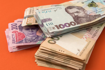 bundle of Ukrainian money isolated on red, stack of hryvnia uah, 200 500 and new 1000 banknote