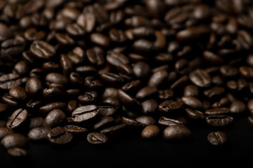 Pile of roasted coffee beans splash on the black background