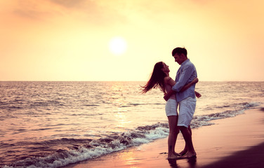  Romantic young Couple hug on the beach at sunset