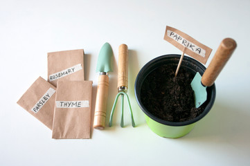 Gardening time, paper bags with seeds and tools for planting. Pot with soil.
