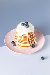 Pancakes with blueberries on a pink plate