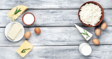 Different types of dairy products on a wooden background. Panorama, with copy space text.
