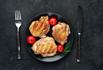 Skinless grilled chicken thighs with spices on a stone background