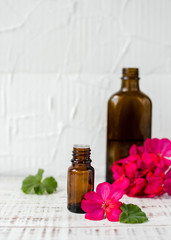 Obraz na płótnie Canvas Geranium oil in glass dark bottles. Pelargonium oil. Aromatherapy