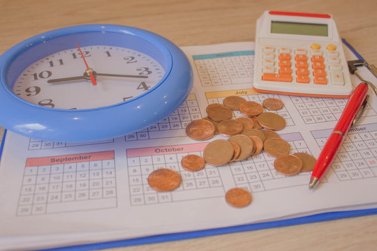financial business calculation with calculator. coin stack with a clock background