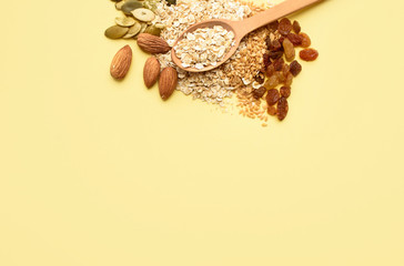 Two spoons of different sizes are filled with oatmeal and golden flax, raisins, almonds, pumpkin seeds. Healthy breakfast, proper nutrition, diet.