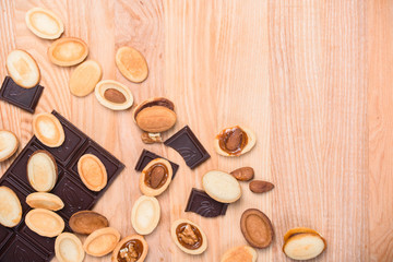 Homemade Russian nuts with condensed milk on a light pink background, wafer napkin. Cut nuts with condensed milk. Bitten goodies for coffee. Condensed Nuts. Flat lay