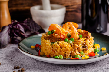 Portuguese cuisine. Risotto rice porridge with vegetables, seafood and shrimp. Beautiful serving dishes in a restaurant on a blue plate.