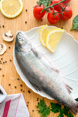 River trout with lemon on a wooden background, view from the top