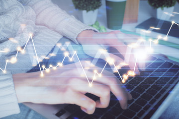 Double exposure of woman hands typing on computer and forex chart hologram drawing. Stock market...
