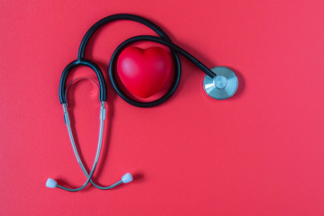 Stethoscope and red heart on red background.